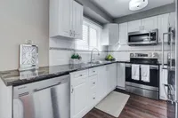 Kitchen with dark granite countertops and stainless steel appliances
