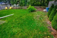 Backyard with a deck, mature trees, and seating area
