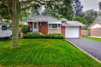 Front exterior of a brick bungalow on Southlea Drive with a mature shade tree and covered porch