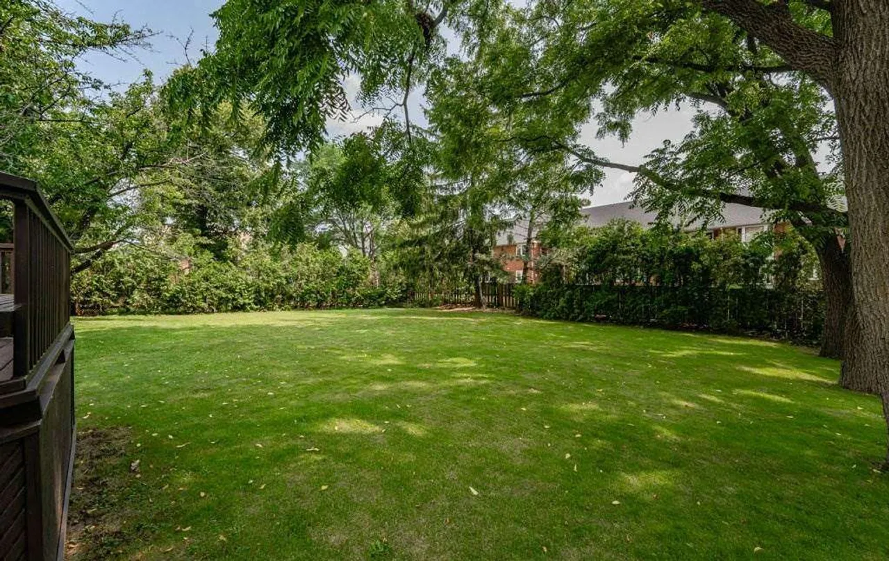 Large, mature backyard with a deck and seating area