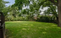 Large, mature backyard with a deck and seating area