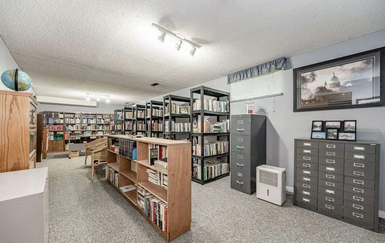 Finished basement set up as a home library with floor-to-ceiling bookshelves
