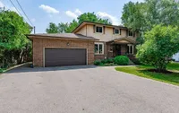 Front exterior of a two-storey brick and wood-sided home on Upper Wellington Street with a 6+ car driveway