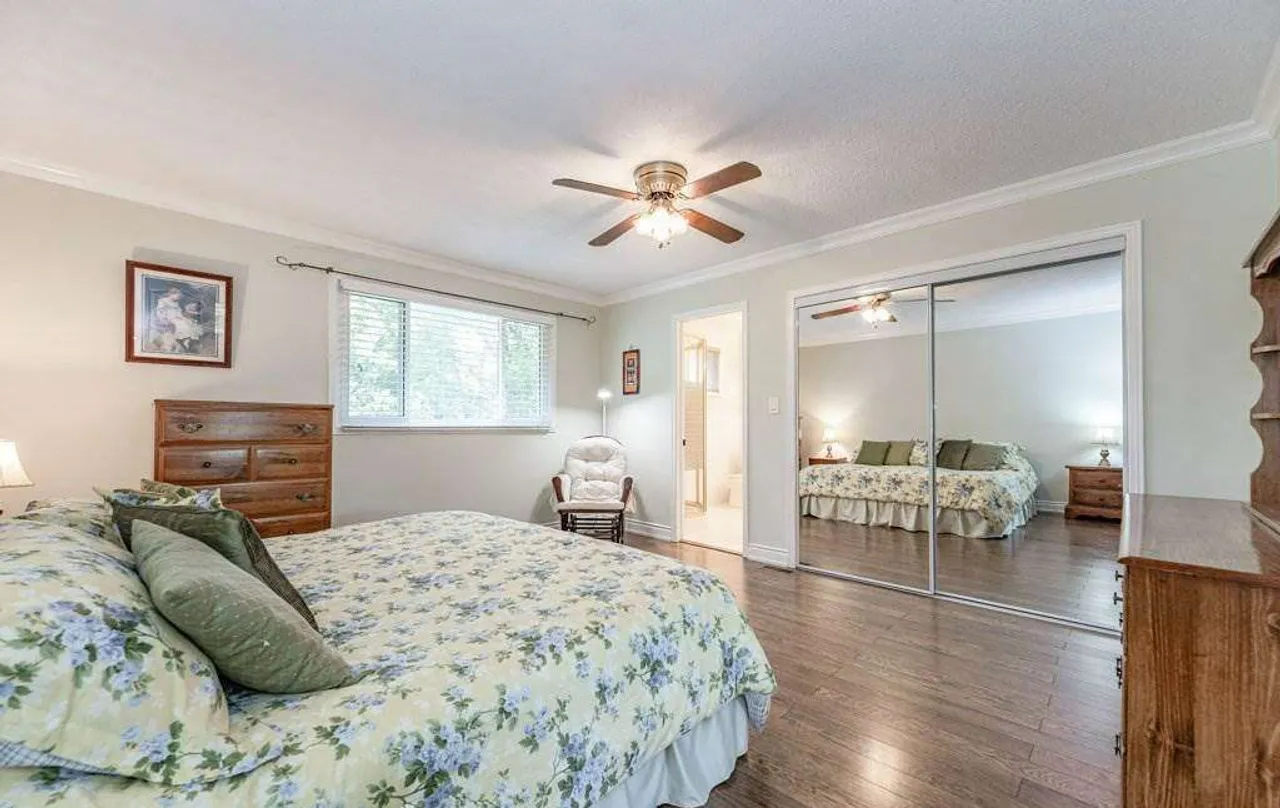Primary bedroom with mirrored sliding closet doors and an ensuite bathroom