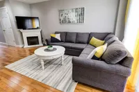 Living room with a stone fireplace and track lighting