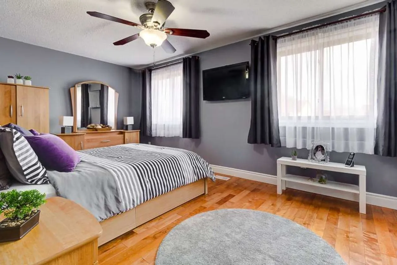 Primary bedroom with a round area rug and ceiling fan