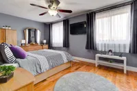 Primary bedroom with a round area rug and ceiling fan