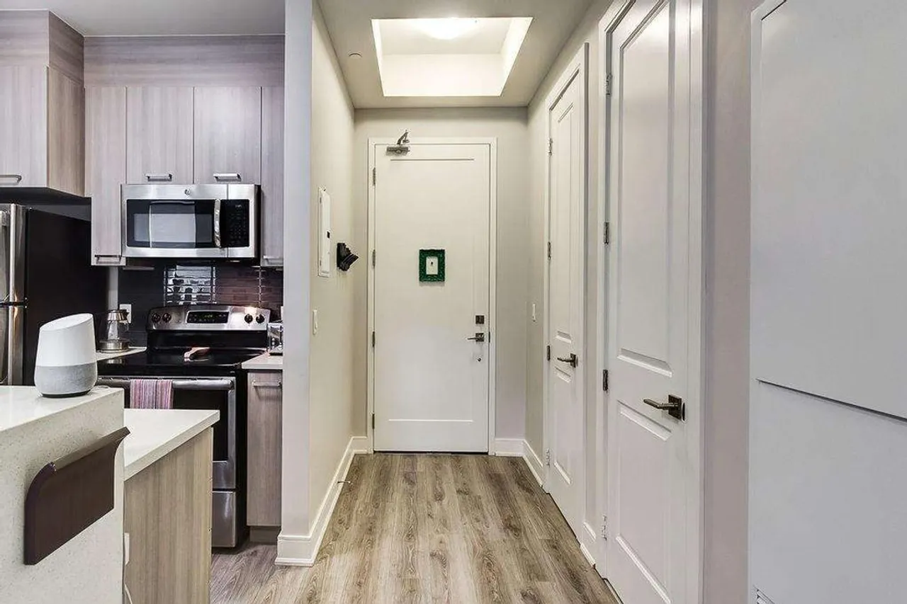Entry hallway with wood-look flooring leading past the kitchen