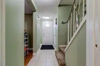 Entryway with tile flooring and a carpeted staircase