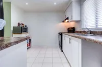 Galley-style kitchen with white cabinetry