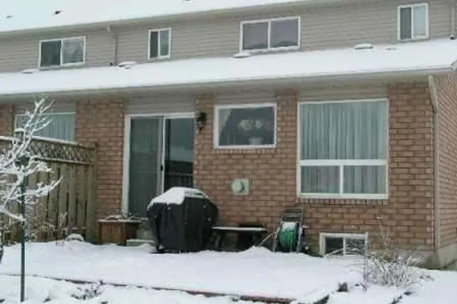 Snow-covered backyard of a brick townhouse on Foxtrot Drive