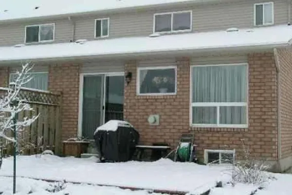 Snow-covered backyard of a brick townhouse on Foxtrot Drive