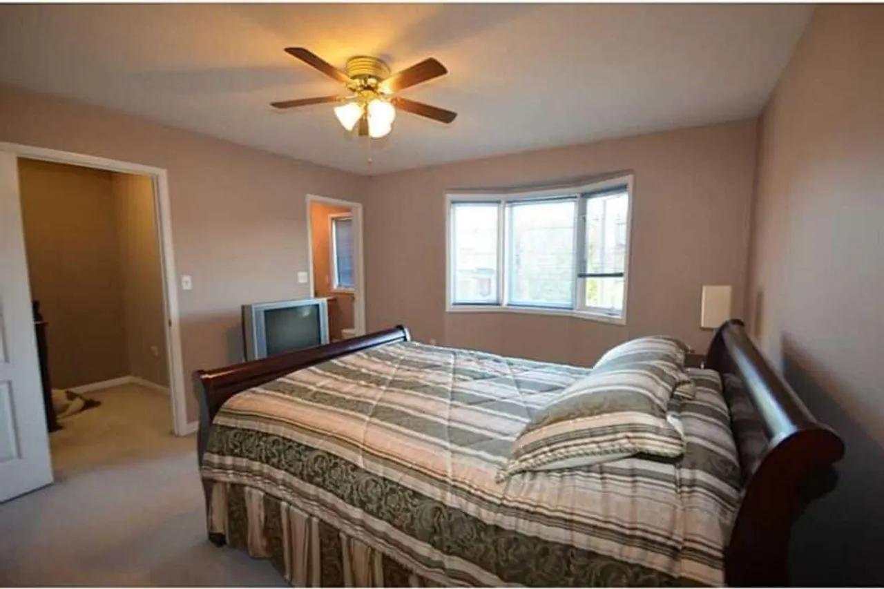 Primary bedroom with a sleigh bed and bay window