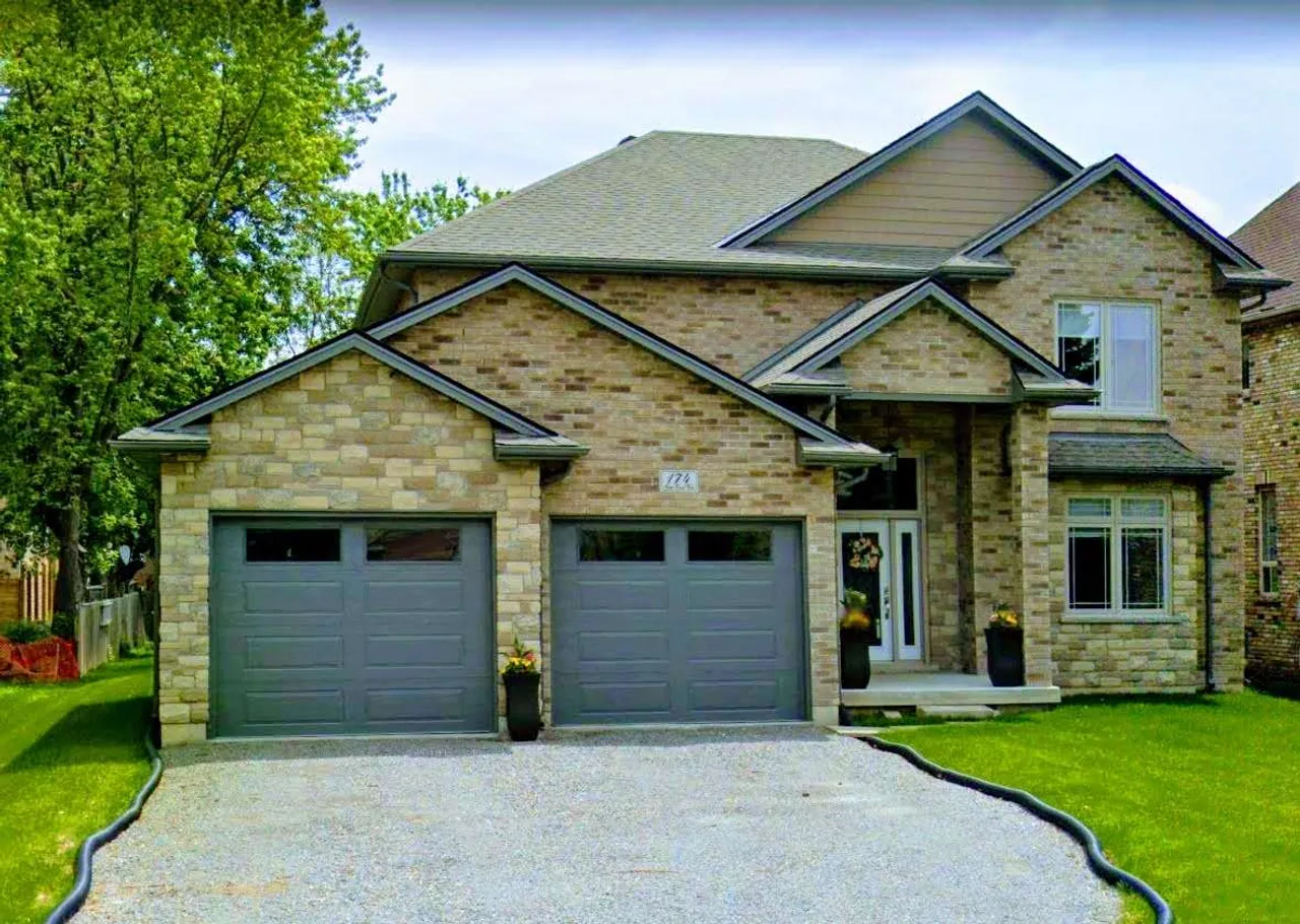 Front exterior of a two-storey brick and stone family home on First Road West in Stoney Creek