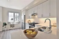 Modern white kitchen with quartz countertops and a window seat nook