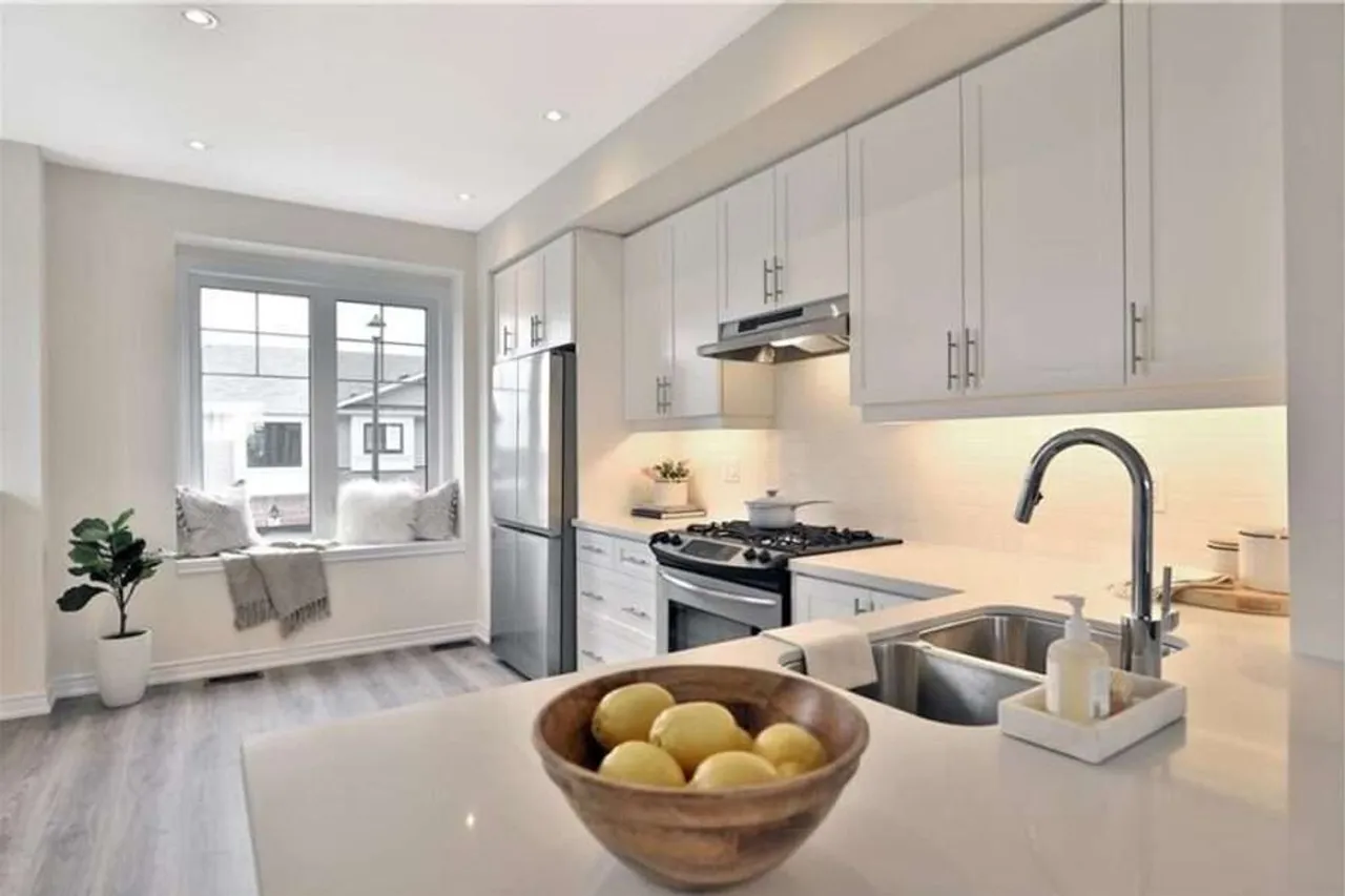 Modern white kitchen with quartz countertops and a window seat nook