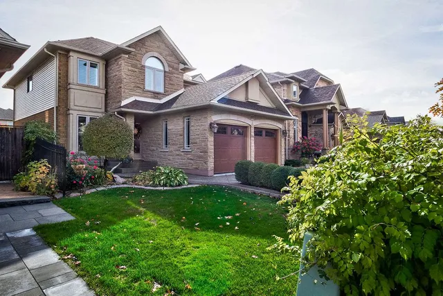 Front exterior of a two-storey brick and stone home on Eringate Drive with a double garage