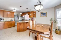Eat-in kitchen with oak cabinetry, a centre island, and a dining area