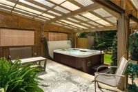 Covered hot tub nestled against the escarpment treeline