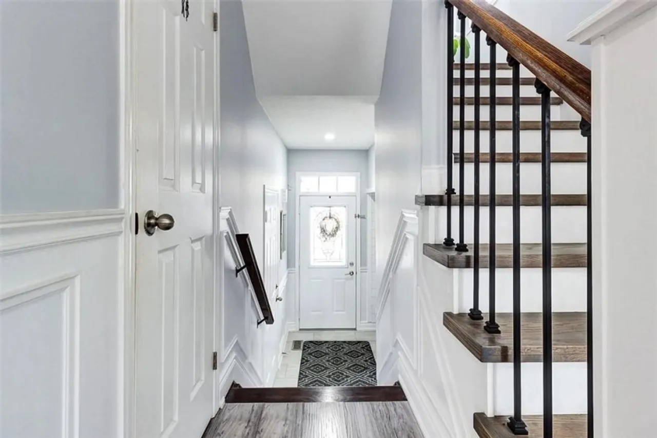 Entryway with tile flooring and a staircase with wrought-iron spindles