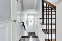 Entryway with tile flooring and a staircase with wrought-iron spindles