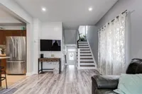 Living room with hardwood flooring and a staircase to the upper level