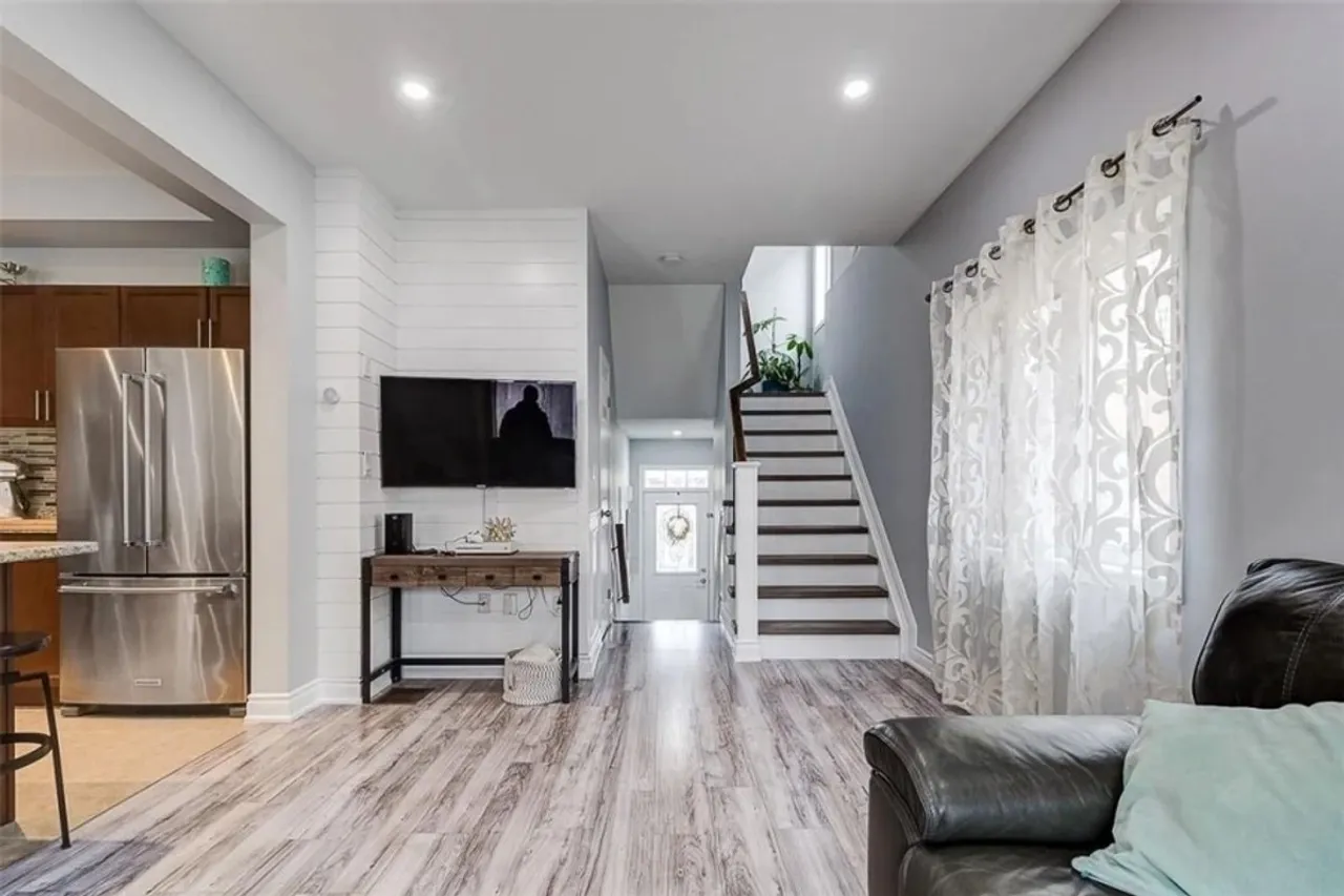 Living room with hardwood flooring and a staircase to the upper level