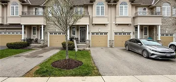 Front exterior of a two-storey brick-and-stucco townhome at 34 Forest Valley Crescent with an attached garage and interlock driveway