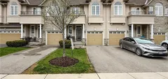 Front exterior of a two-storey brick-and-stucco townhome at 34 Forest Valley Crescent with an attached garage and interlock driveway
