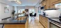 Open-concept kitchen with granite countertops, stainless steel appliances, and a view through to the dining and living areas