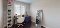 Primary bedroom with a large window and dark hardwood flooring