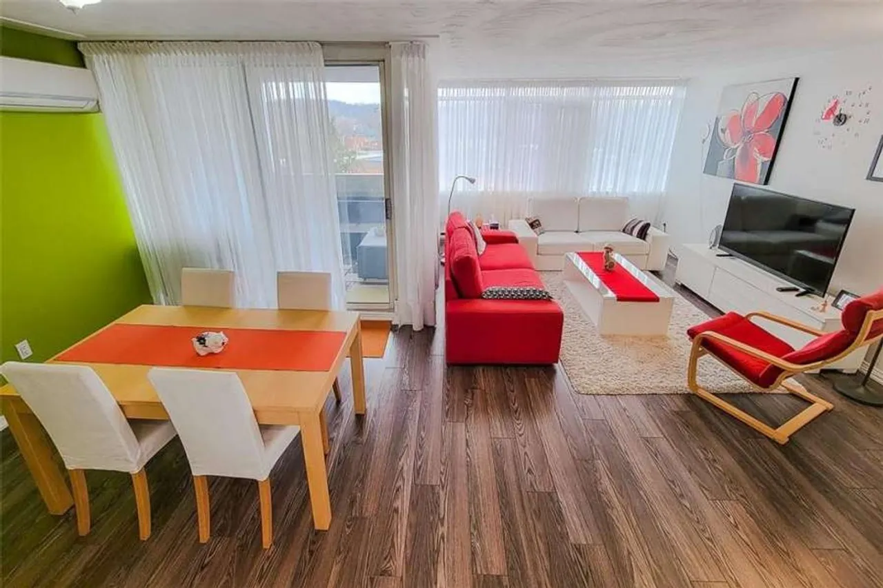 Living and dining room with a walkout to a private balcony