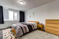 Primary bedroom with city views through a large window