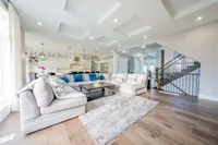 Great room with a coffered ceiling, sectional sofa, and wide-plank hardwood floors