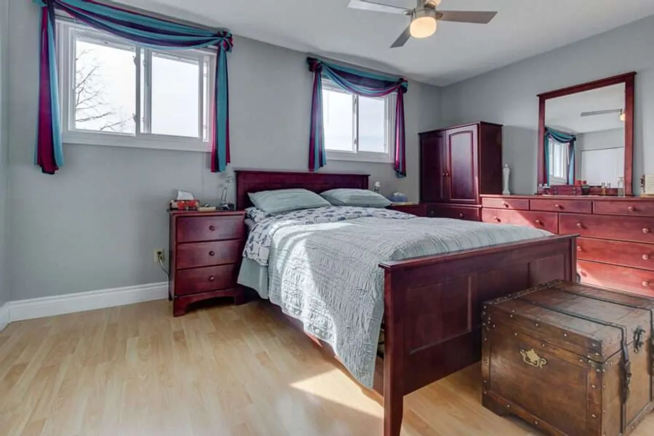 Primary bedroom with multiple windows and a ceiling fan