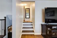 Split-level staircase landing with a wall-mounted television