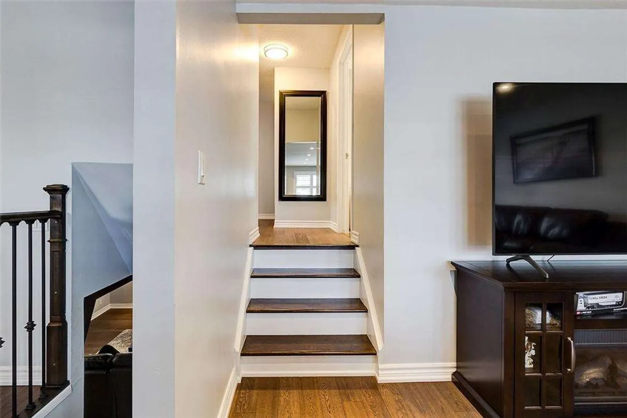 Split-level staircase landing with a wall-mounted television