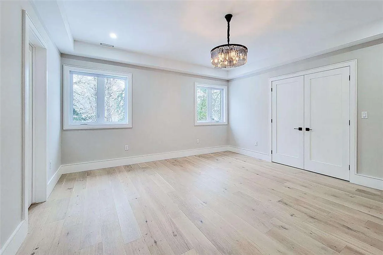 Bright upper-level bedroom with a crystal chandelier and double closet doors