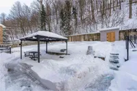 Snow-covered backyard with a gazebo and storage shed