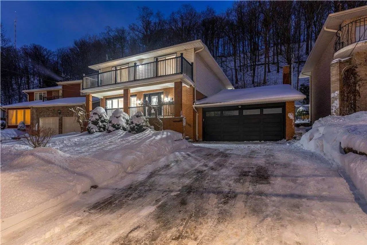Front exterior at twilight with the escarpment backdrop lit up