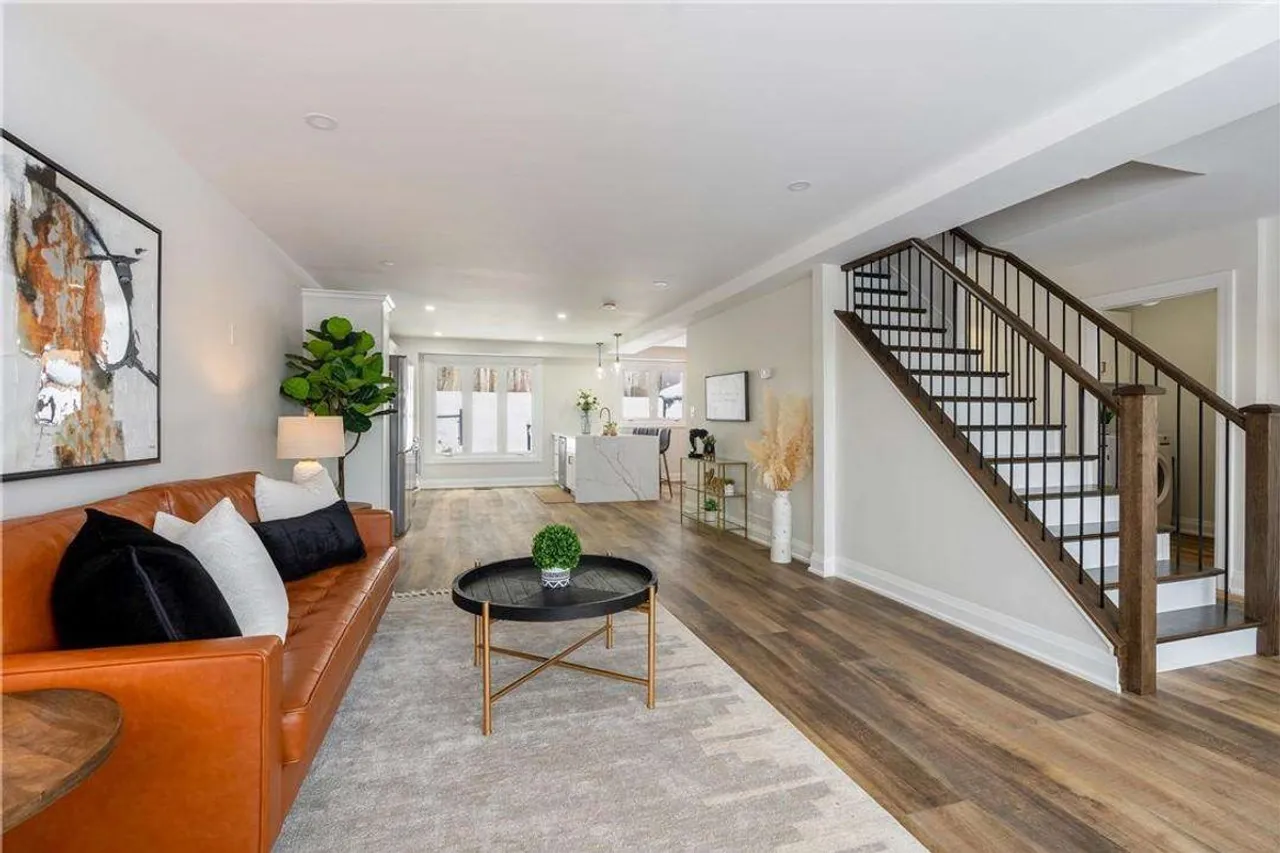 In-law suite living room with an orange leather sofa and staircase