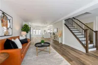 In-law suite living room with an orange leather sofa and staircase