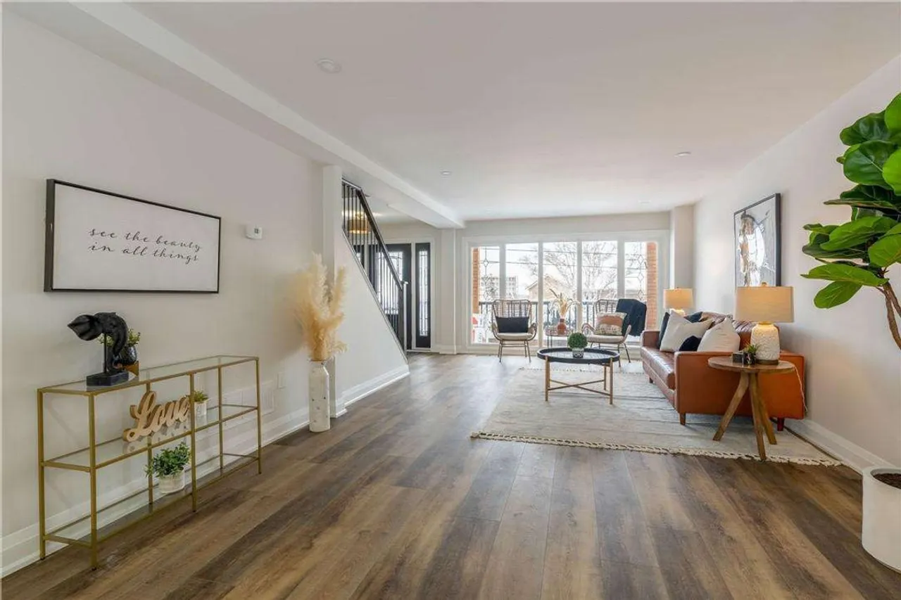 Main floor living room with leather sofa and a walkout to the balcony