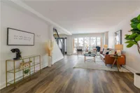 Main floor living room with leather sofa and a walkout to the balcony