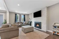 Living room with a stacked stone fireplace and wall-mounted TV