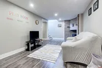 Finished basement playroom and recreation area with a stone fireplace