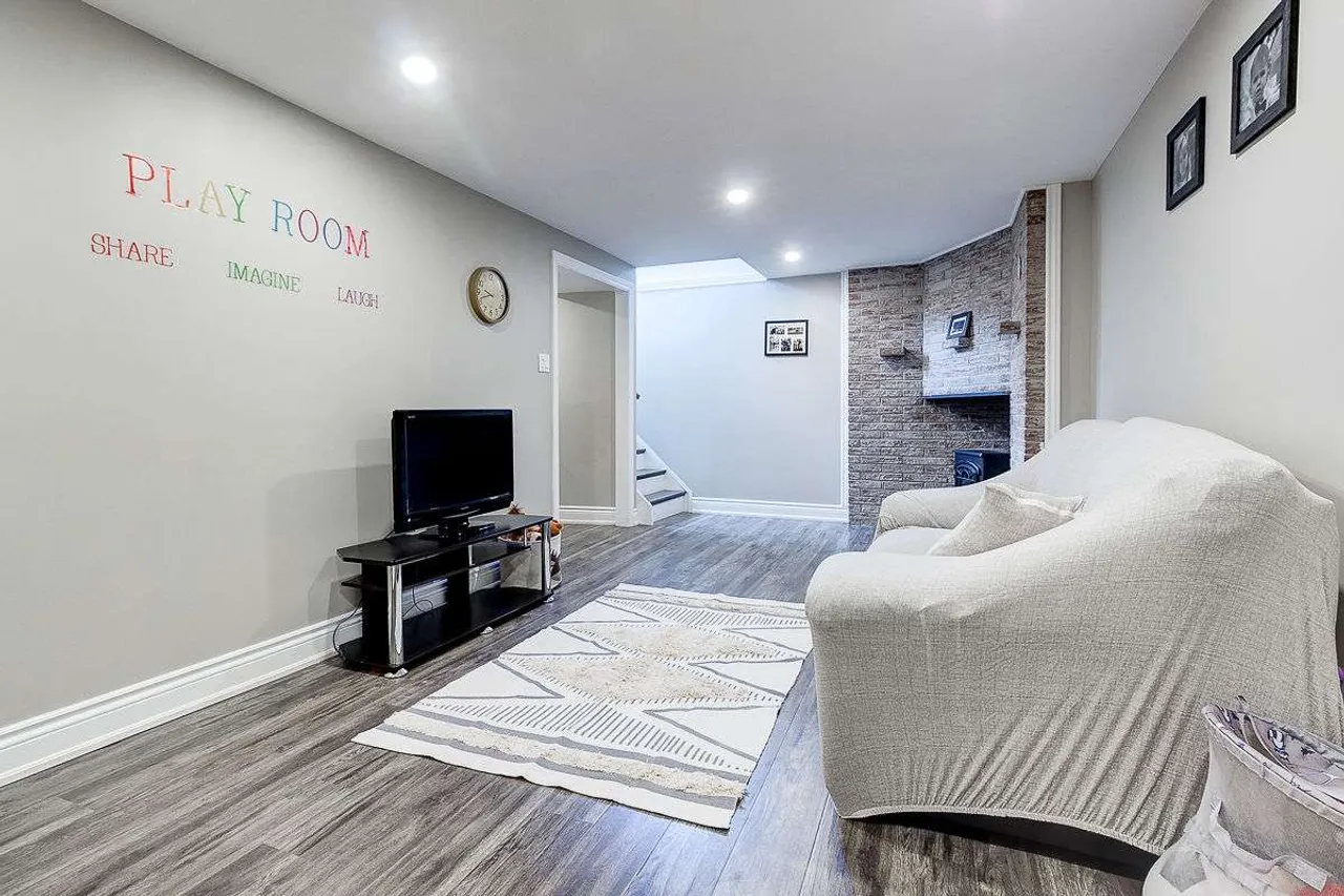 Finished basement playroom and recreation area with a stone fireplace