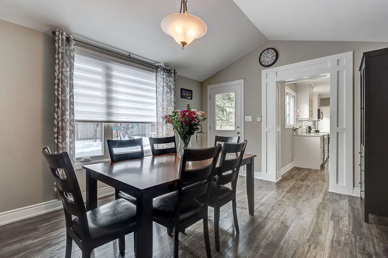 Dining room with a vaulted ceiling, pendant light, and walkout to the backyard