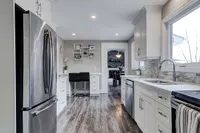 Updated eat-in kitchen with white cabinetry, stainless steel appliances, and a breakfast nook