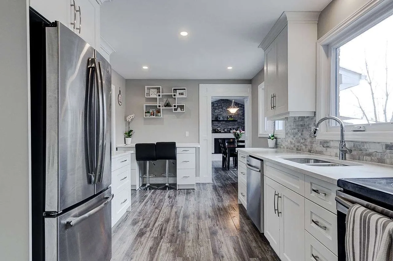 Updated eat-in kitchen with white cabinetry, stainless steel appliances, and a breakfast nook